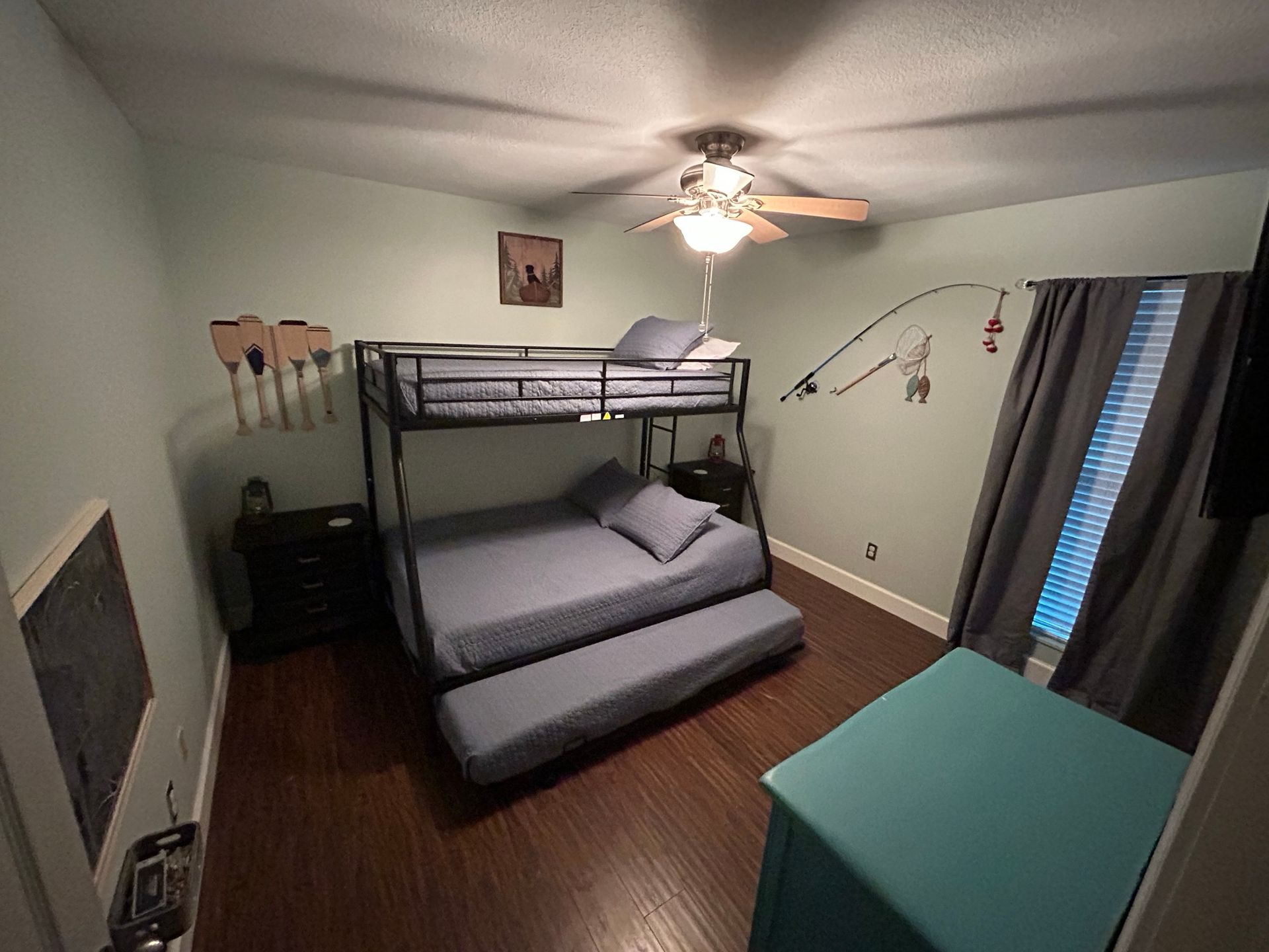 A bedroom with a bunk bed and a ceiling fan.