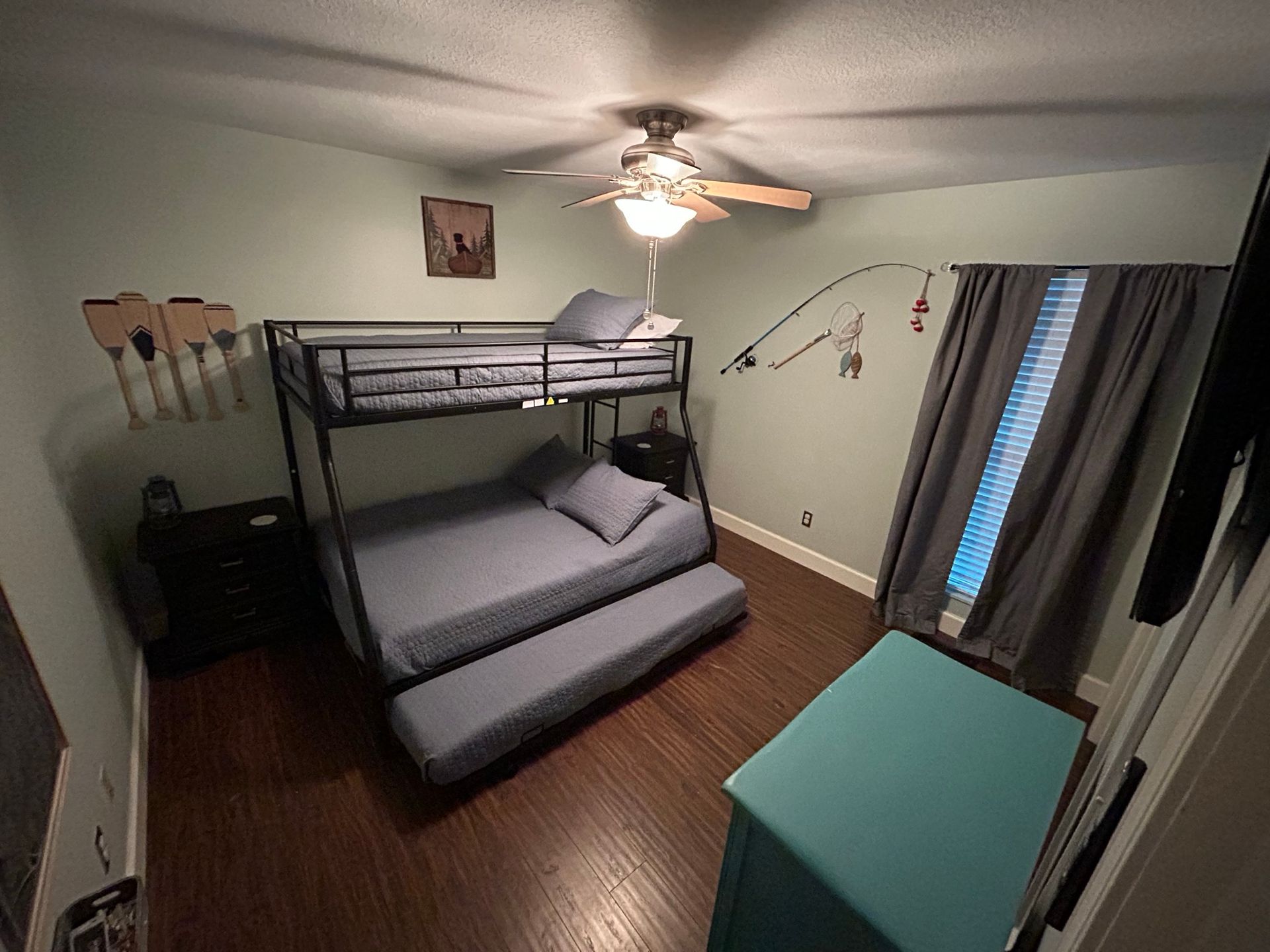 A bedroom with a bunk bed and a ceiling fan.