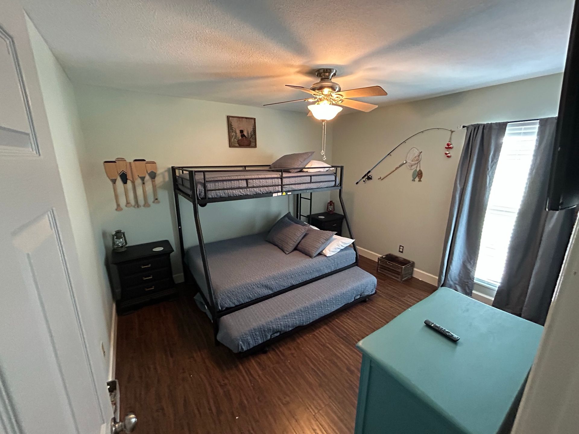 A bedroom with a bunk bed and a ceiling fan.