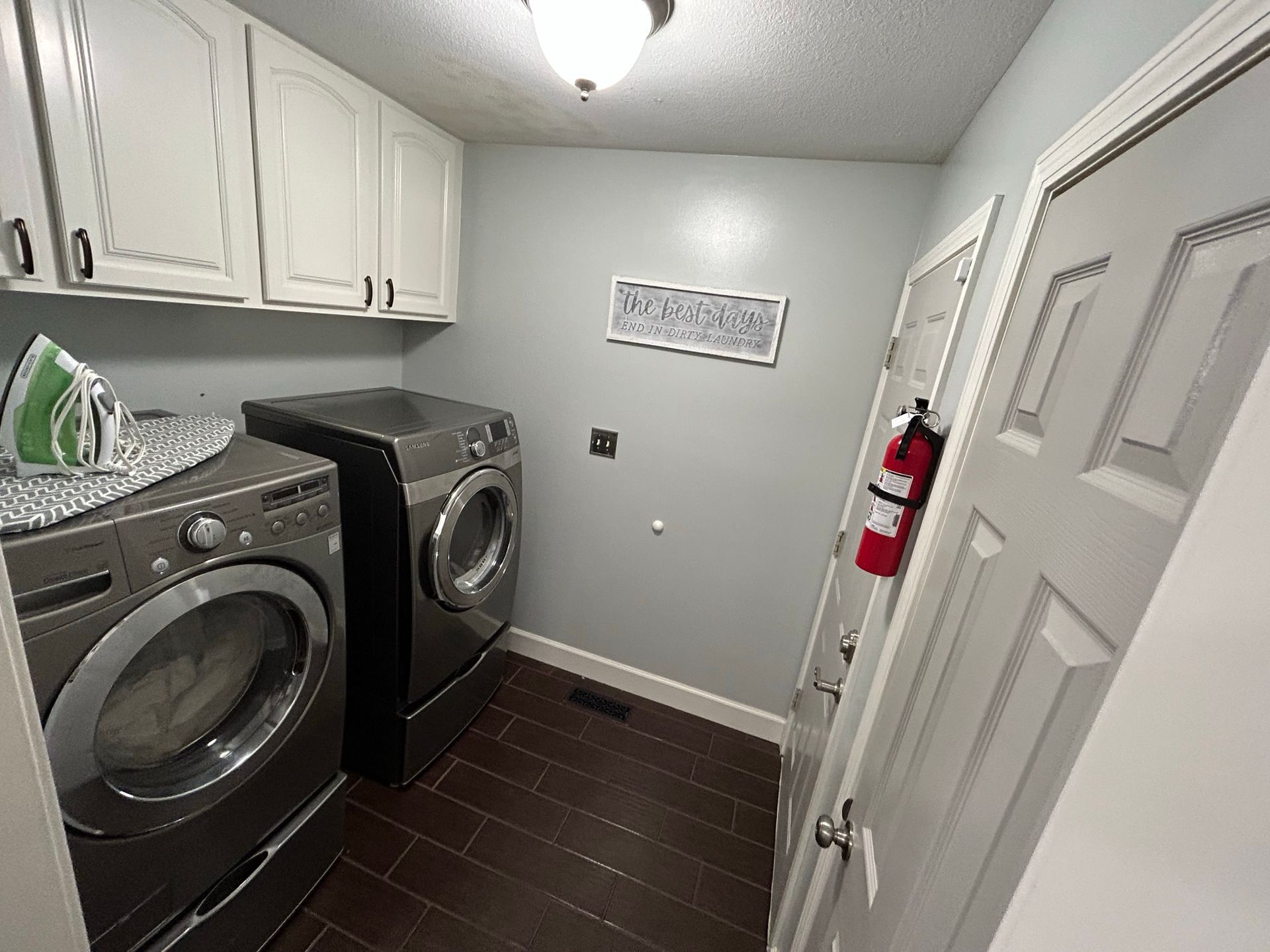 A laundry room with a washer and dryer and a fire extinguisher.