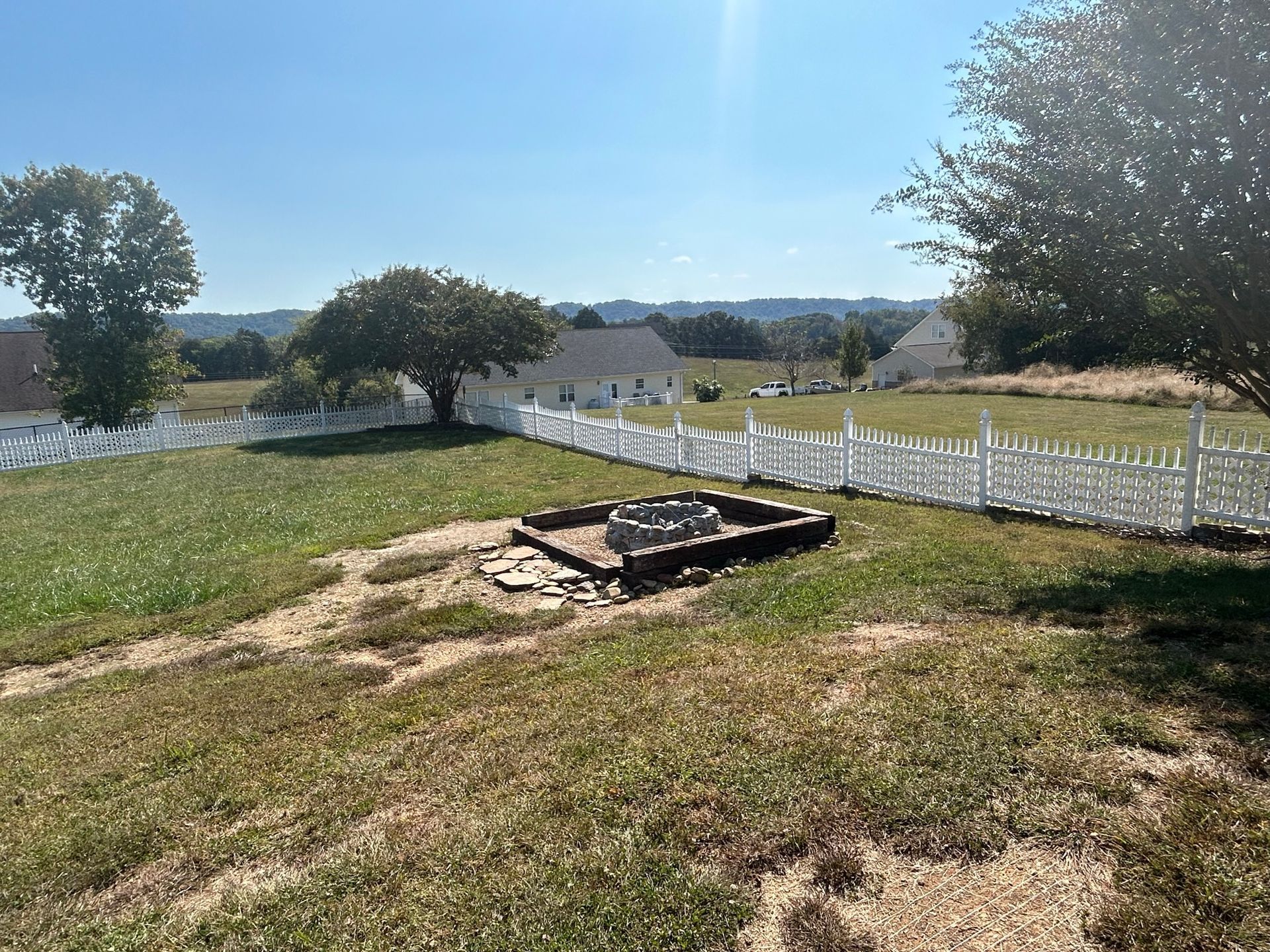 There is a fire pit in the middle of a grassy field.