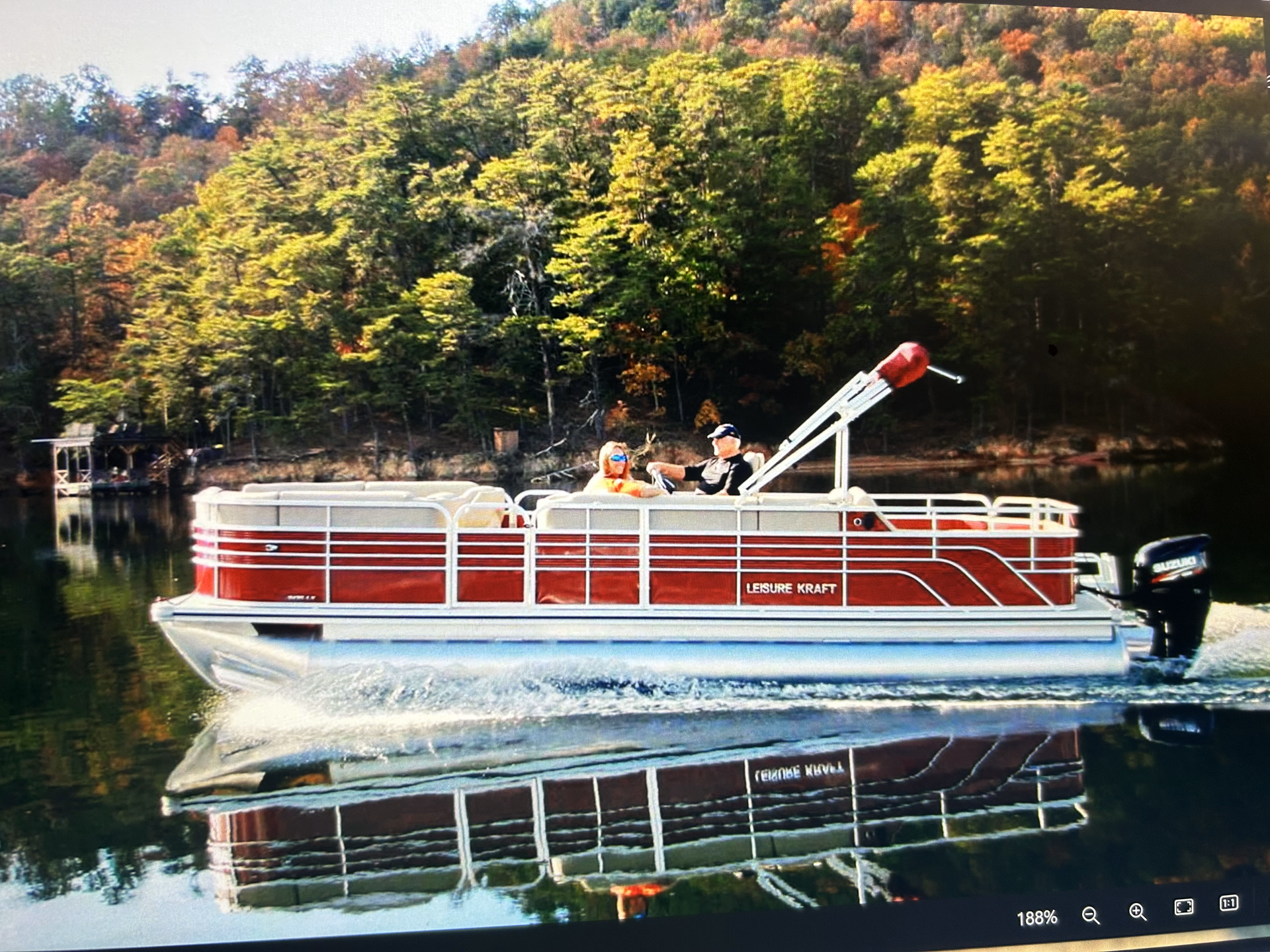 A red pontoon boat is floating on Norris lake