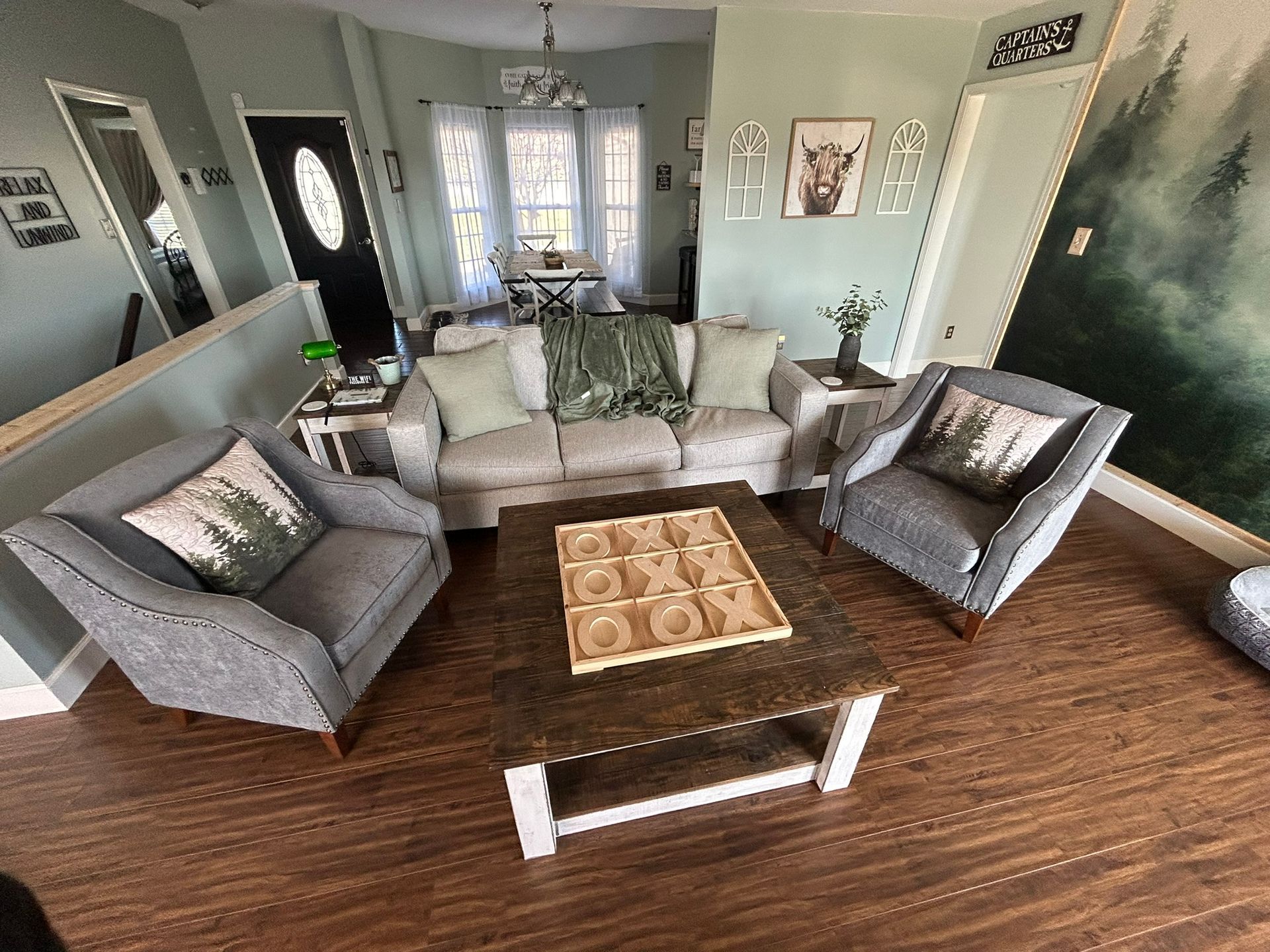 A living room with a couch , chairs , and a coffee table.