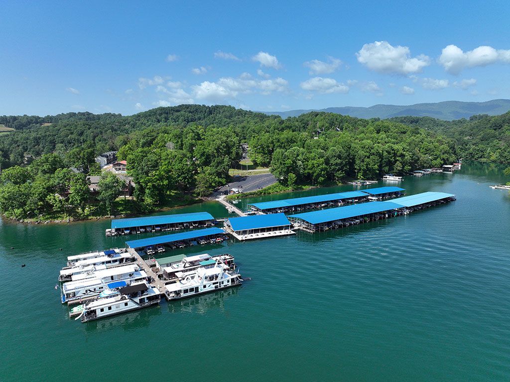 An aerial view of a boat dock on a lake surrounded by trees.