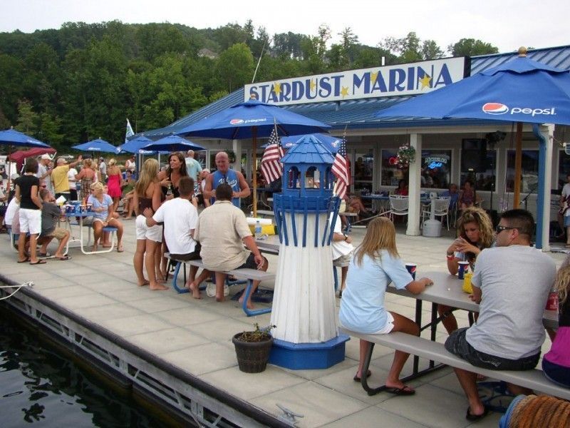 A group of people are sitting at picnic tables at the stardust marina