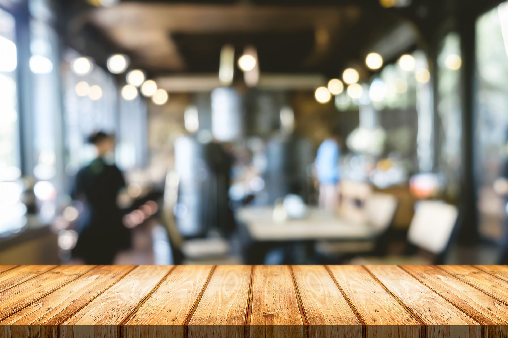A wooden table with a blurry background of a restaurant.