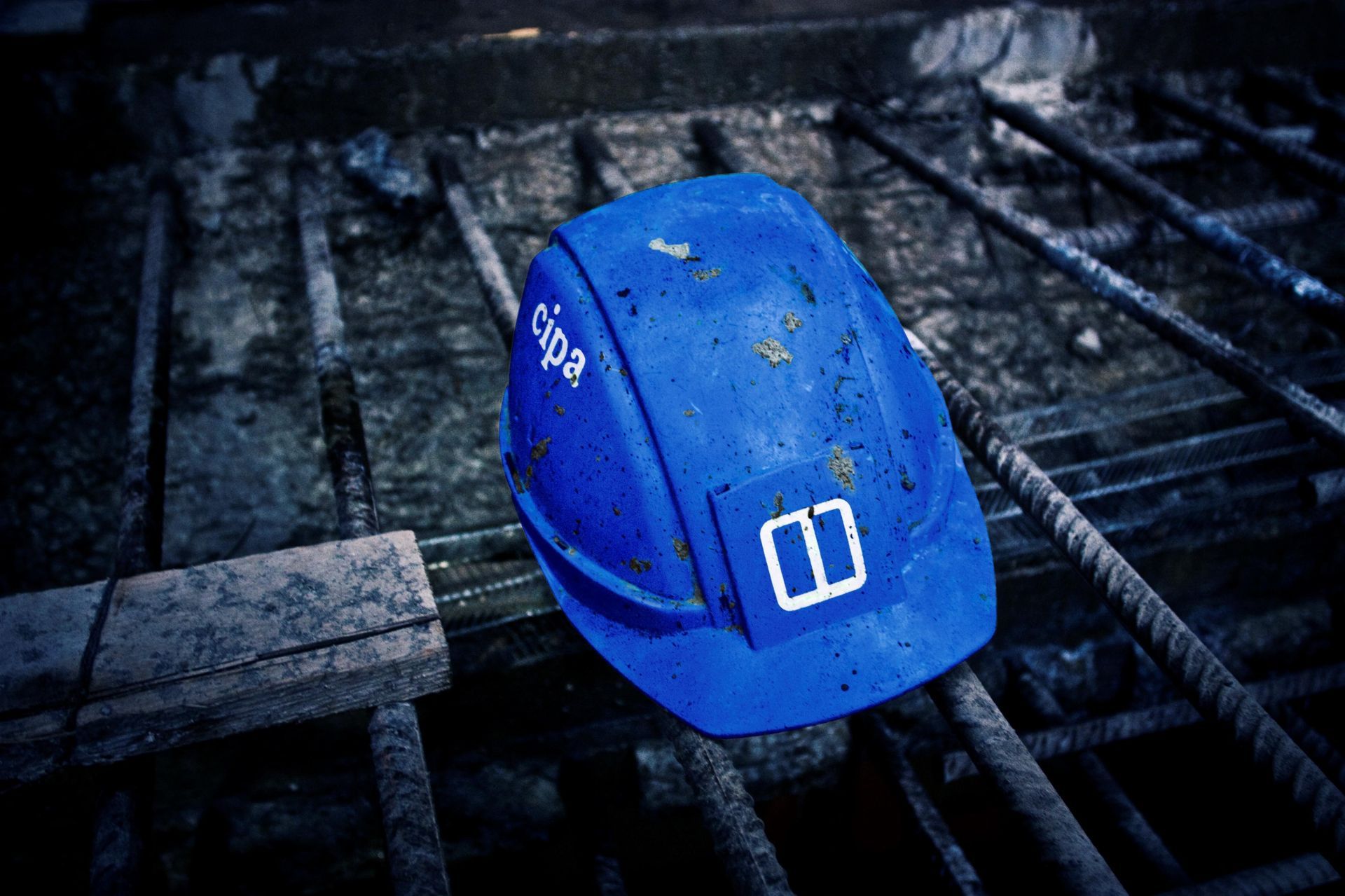 Casco blu su barre d'armatura in un cantiere edile.