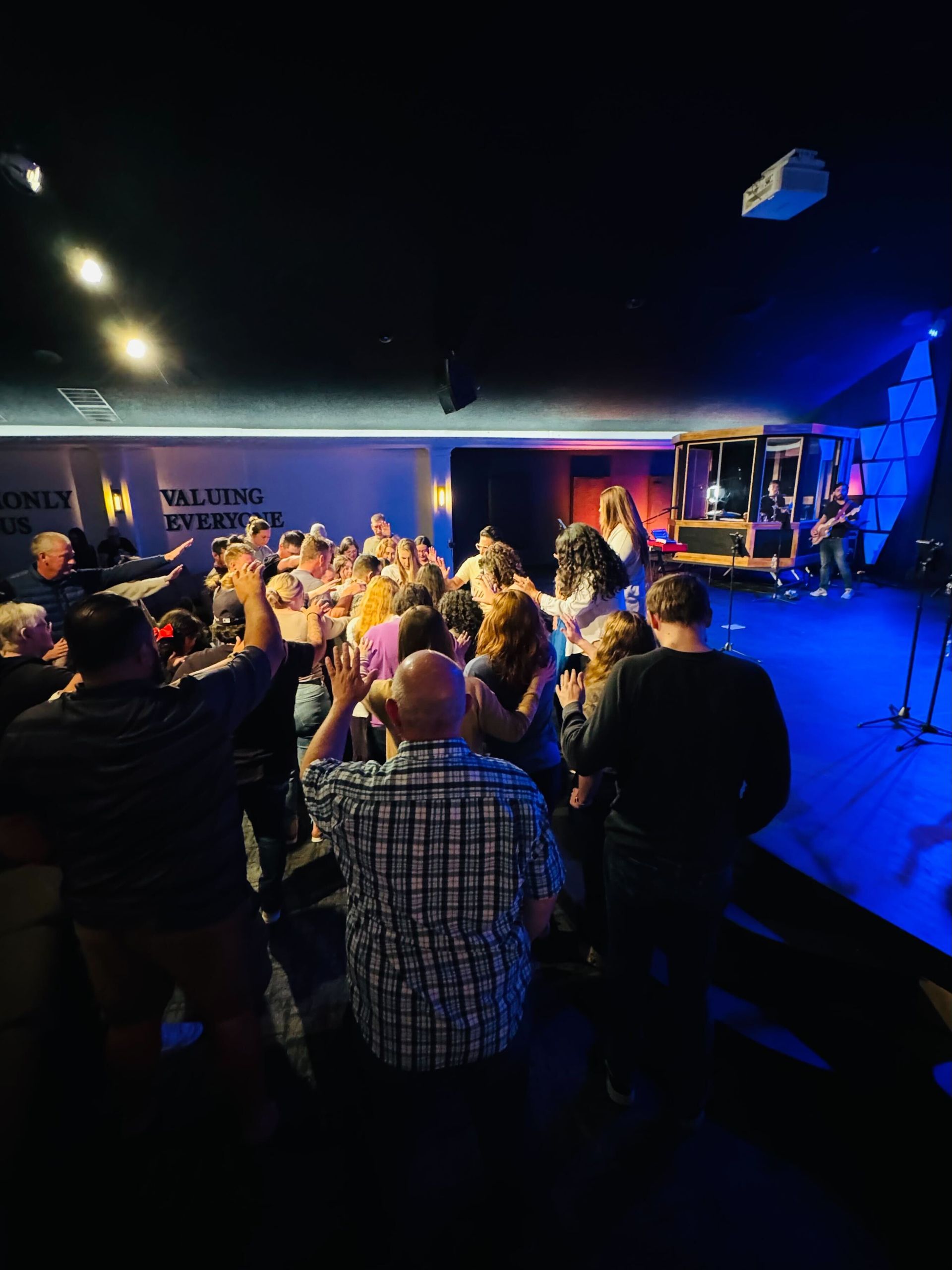 A crowd of people are standing in front of a stage at a concert.
