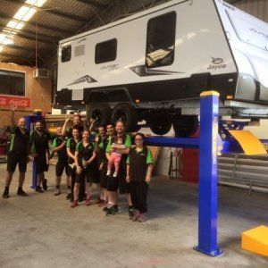 A group of people standing in front of a camper on a lift