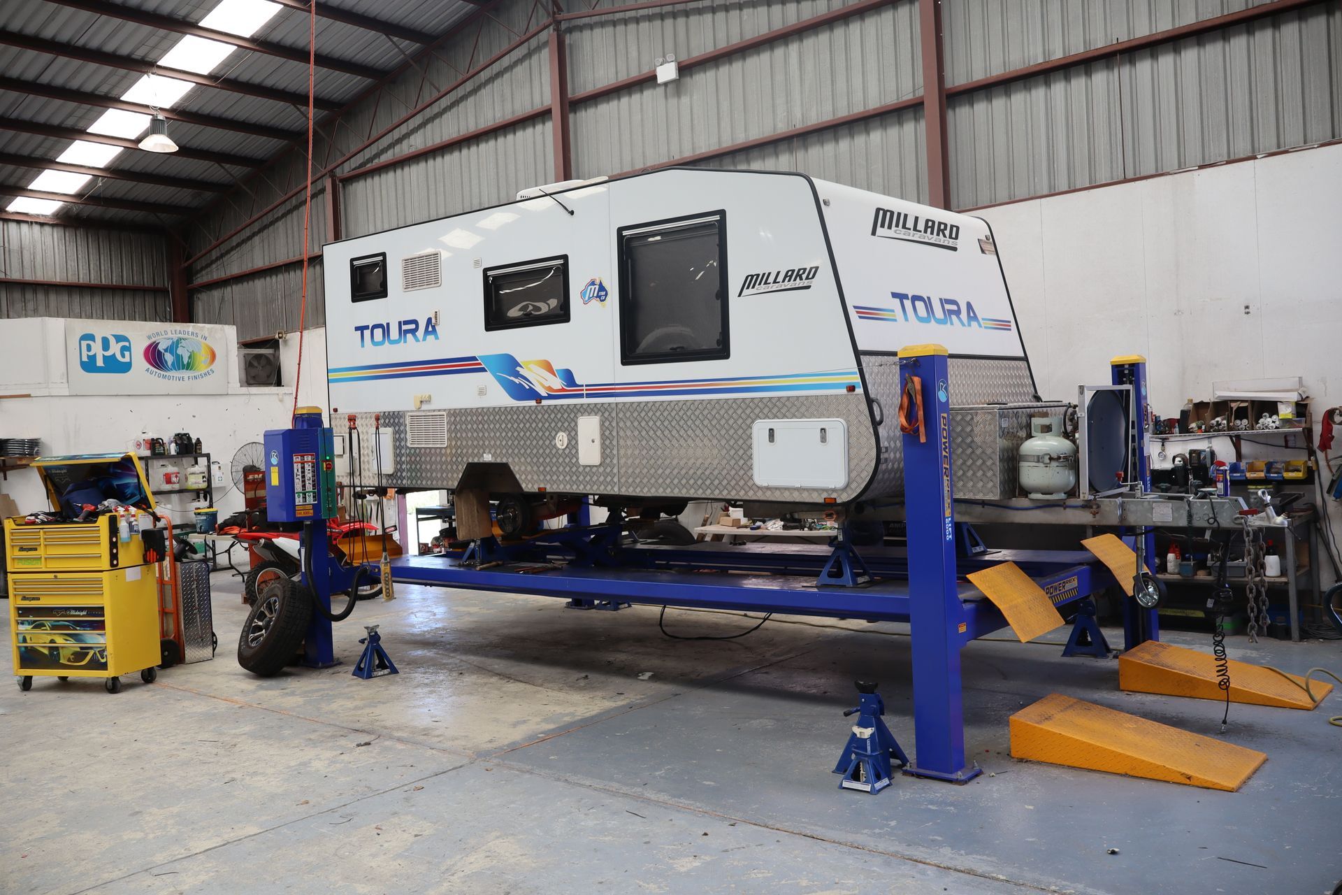 A caravan on a hoist being serviced.