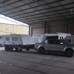 A truck is pulling a trailer in a parking lot.