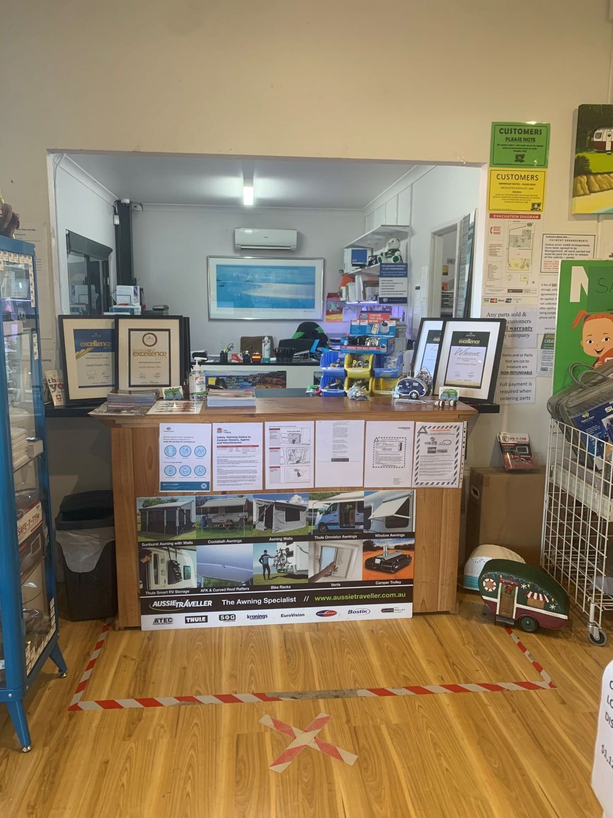 The inside of a store with a wooden floor and a counter.