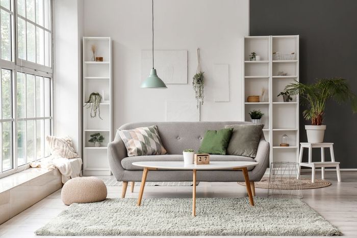 A living room with a couch , coffee table , and shelves.