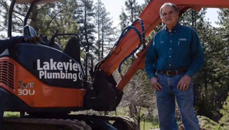 Man Standing Next To Backhoe — Truckee, CA — Lakeview Plumbing Company