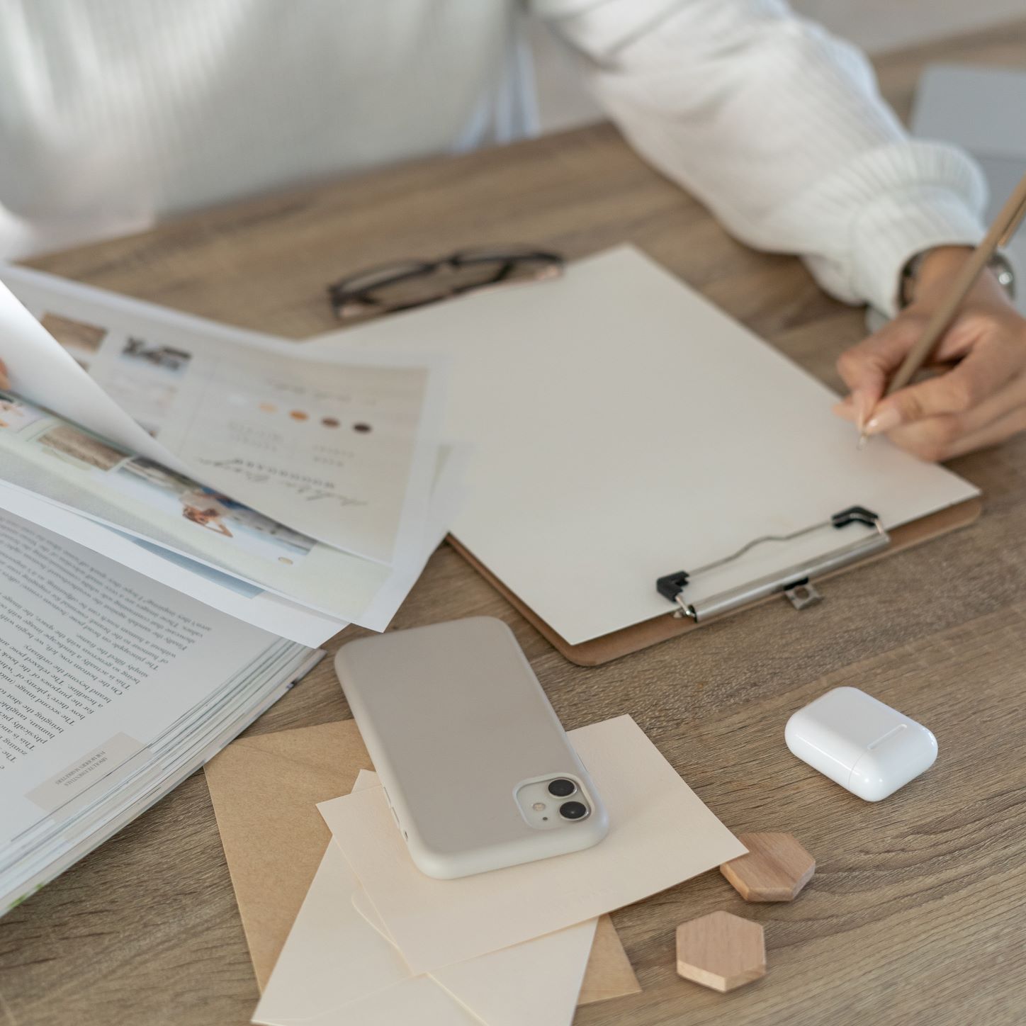 A virtual assistant taking notes on marketing campaign. Cell phone, glasses, marketing materials.