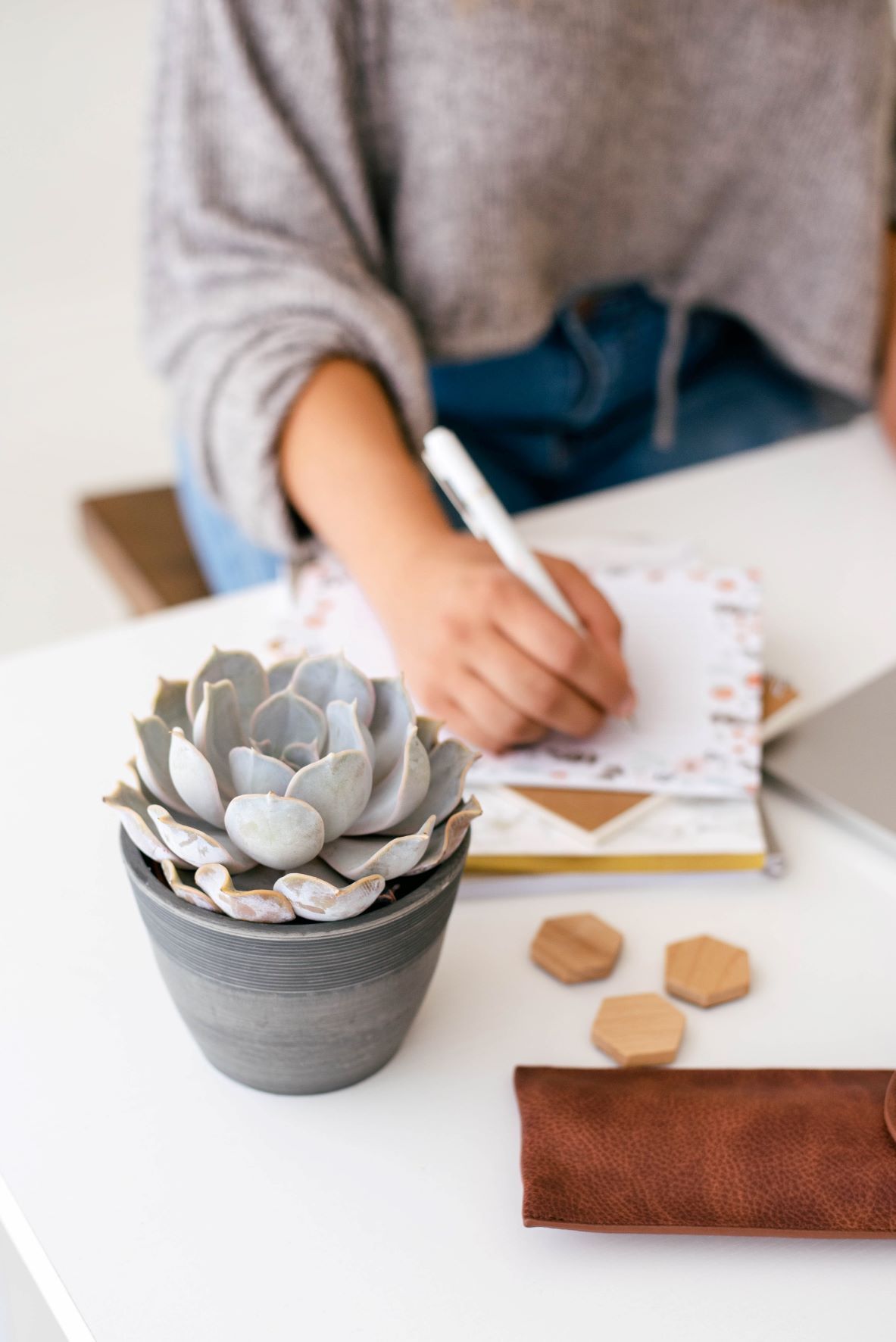 Virtual assistant writing task list on piece of paper for marketing plan