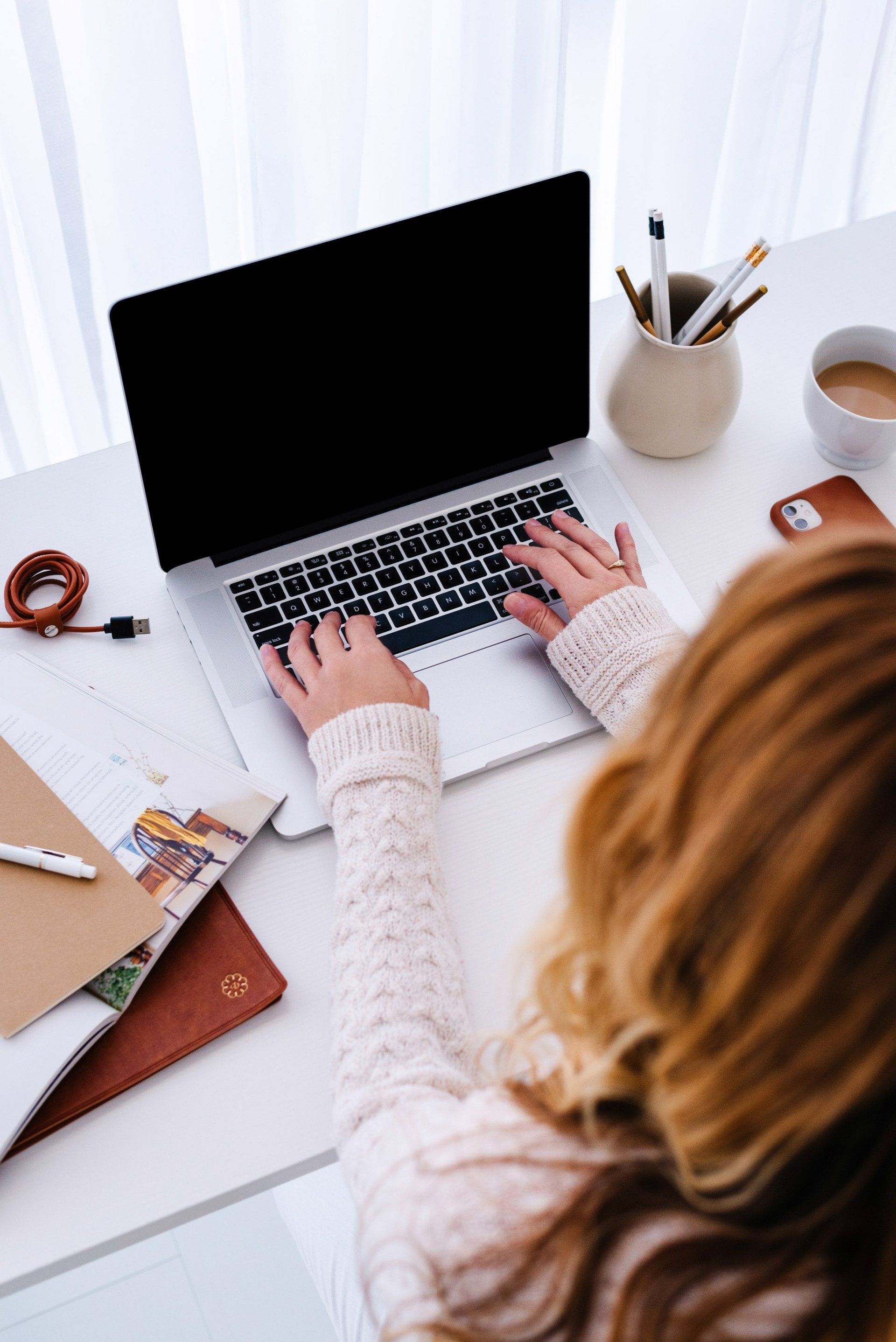 Virtual assistant woman types on laptop, office supplies