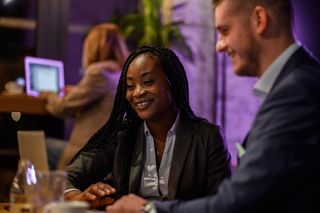 A man and a woman are sitting at a table in a restaurant.