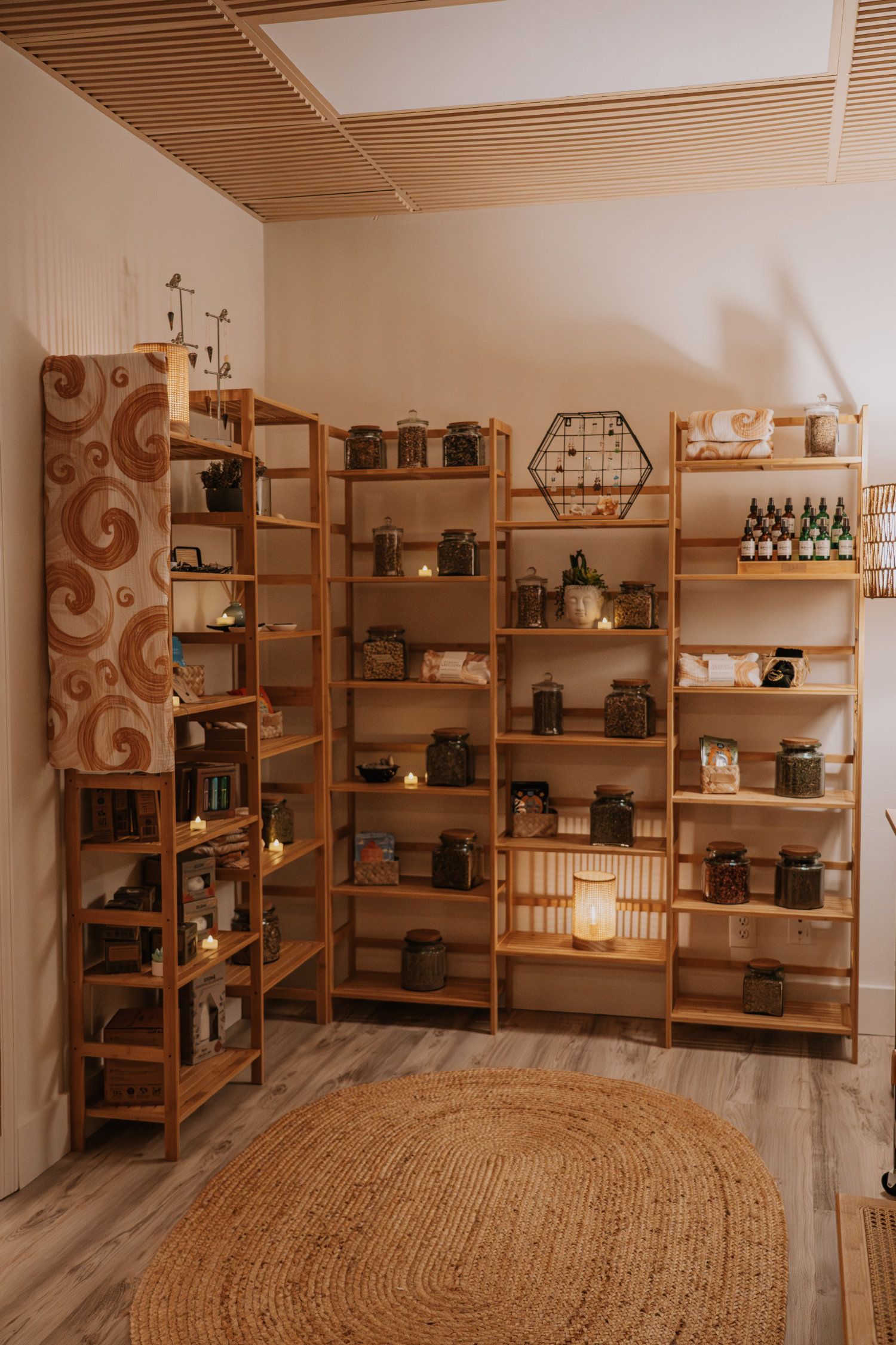 Wooden shelves filled with jars and small items, arranged in a corner of a room with a rug.