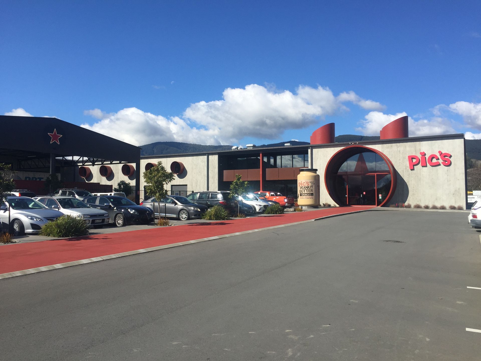 A large building with a lot of cars parked in front of it.