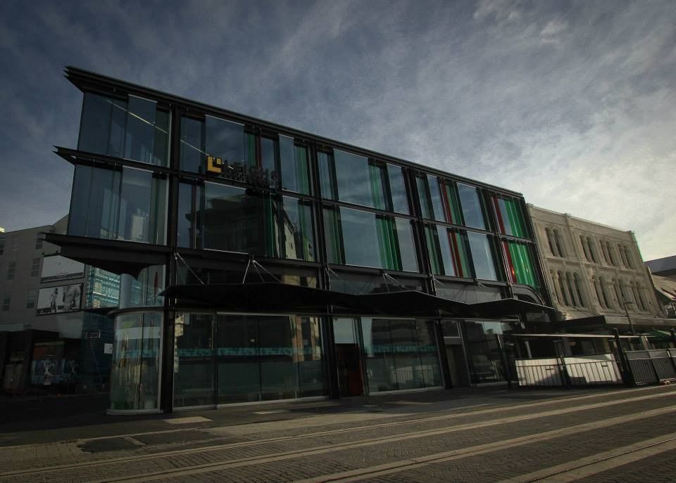 A large building with a lot of windows and a bus parked in front of it.