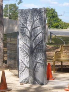 A cemetery scene with a cross-shaped headstone and a smaller cross. Green grass and other headstones are visible.