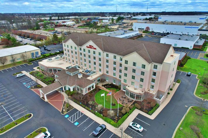 An aerial view of a large hotel with a lot of cars parked in front of it.