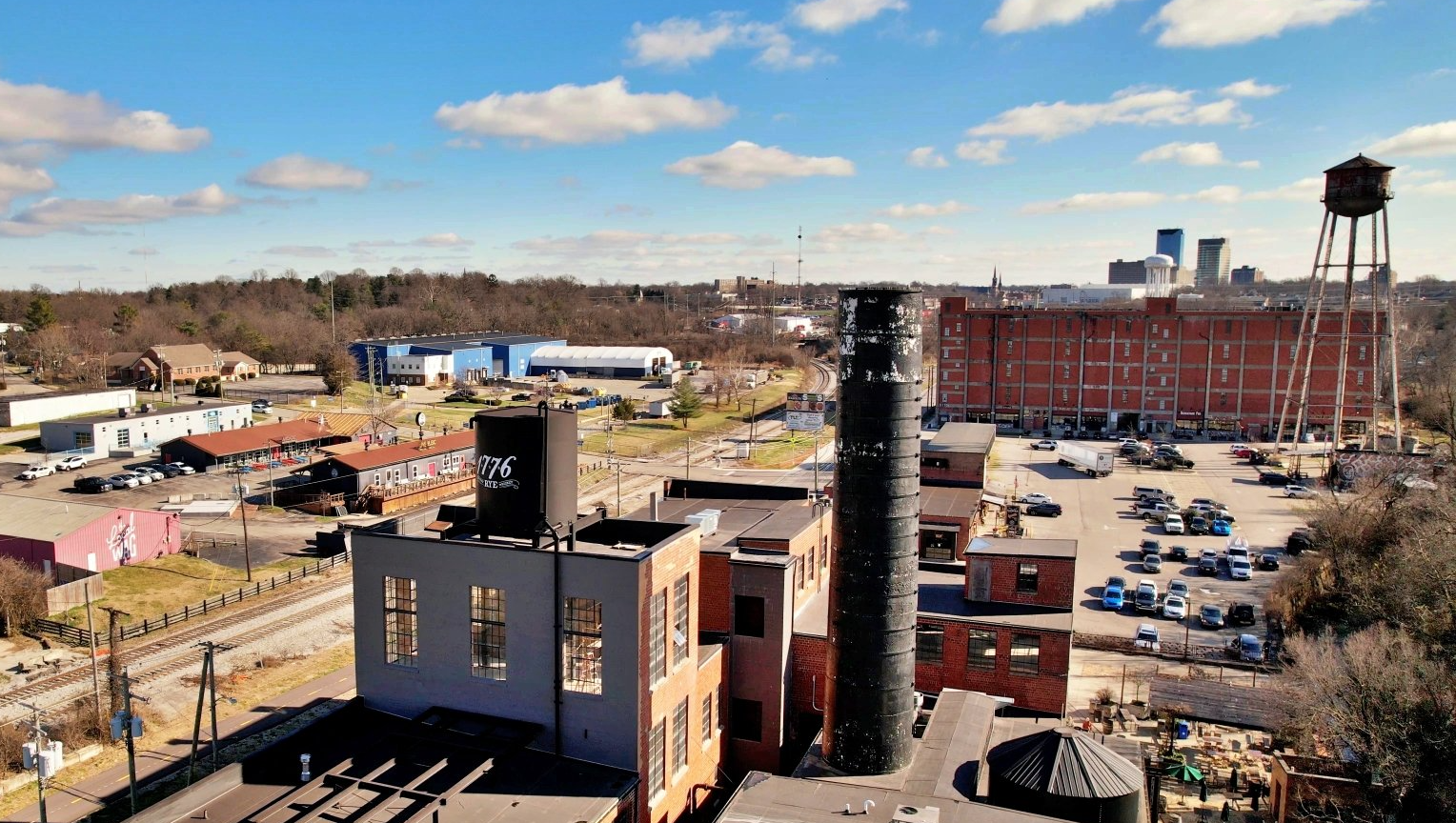An aerial view of a factory with a water tower in the background.