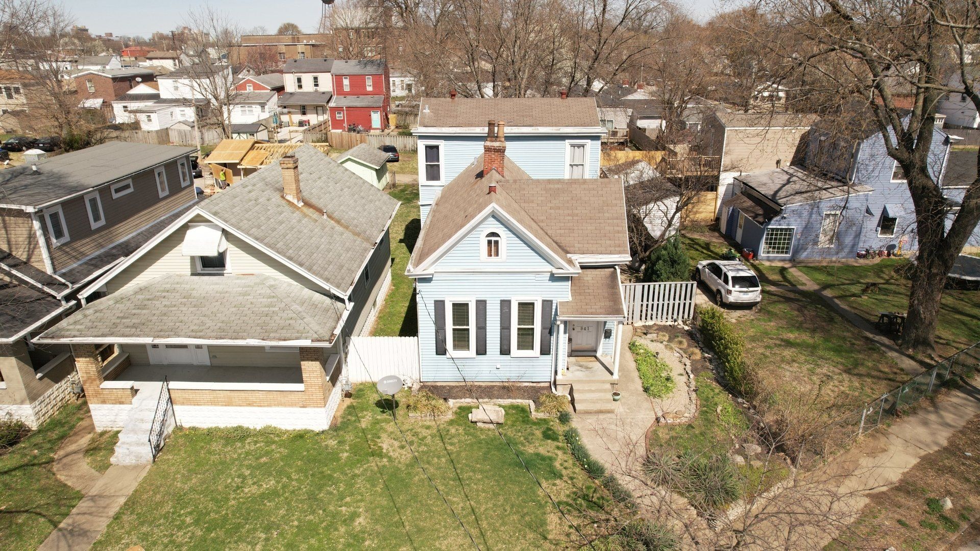 An aerial view of a residential area with a blue house in the middle.