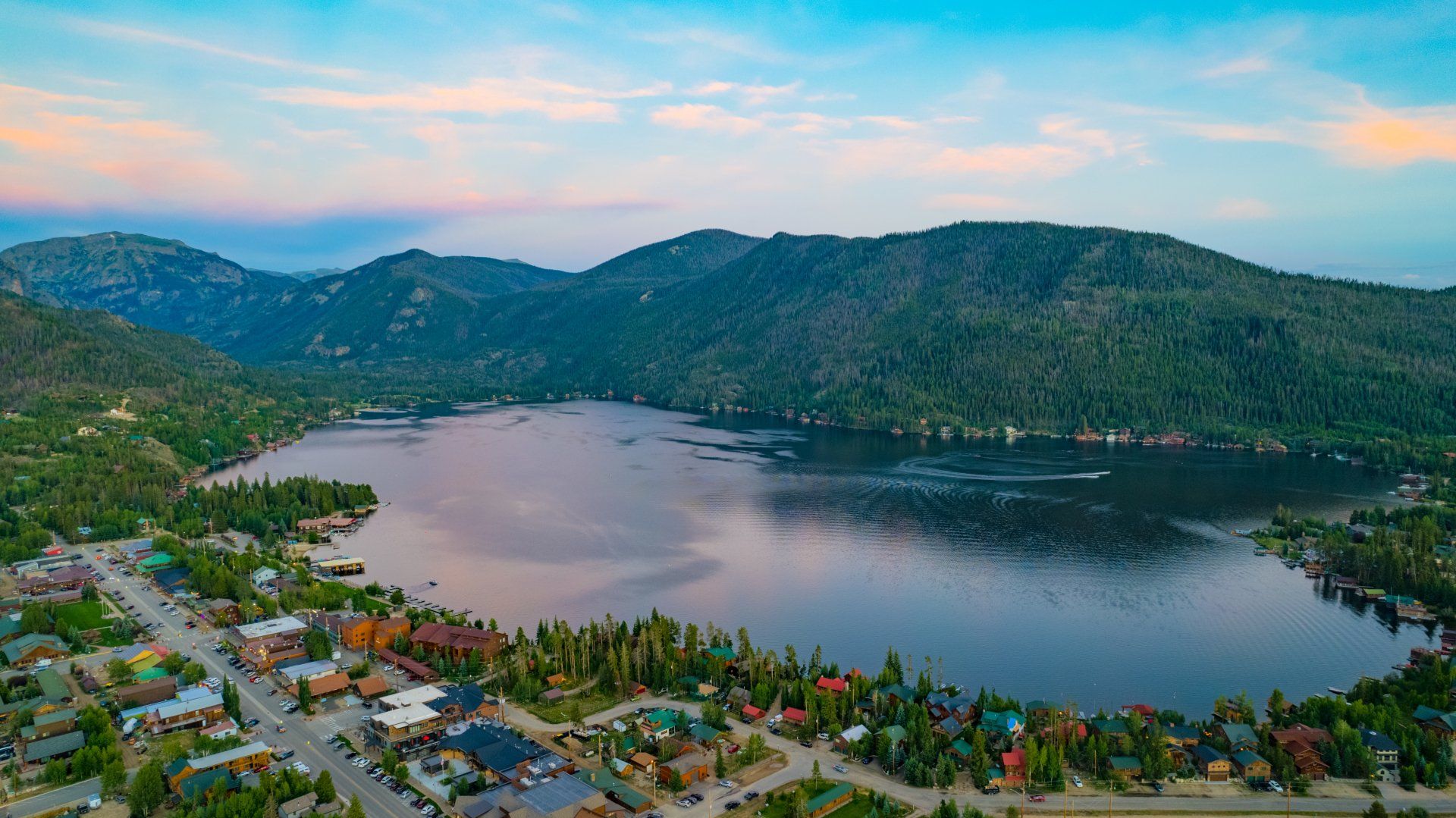 An aerial view of a lake surrounded by mountains and houses.