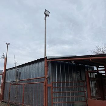 A metal building with a red gate and a light on top of it.
