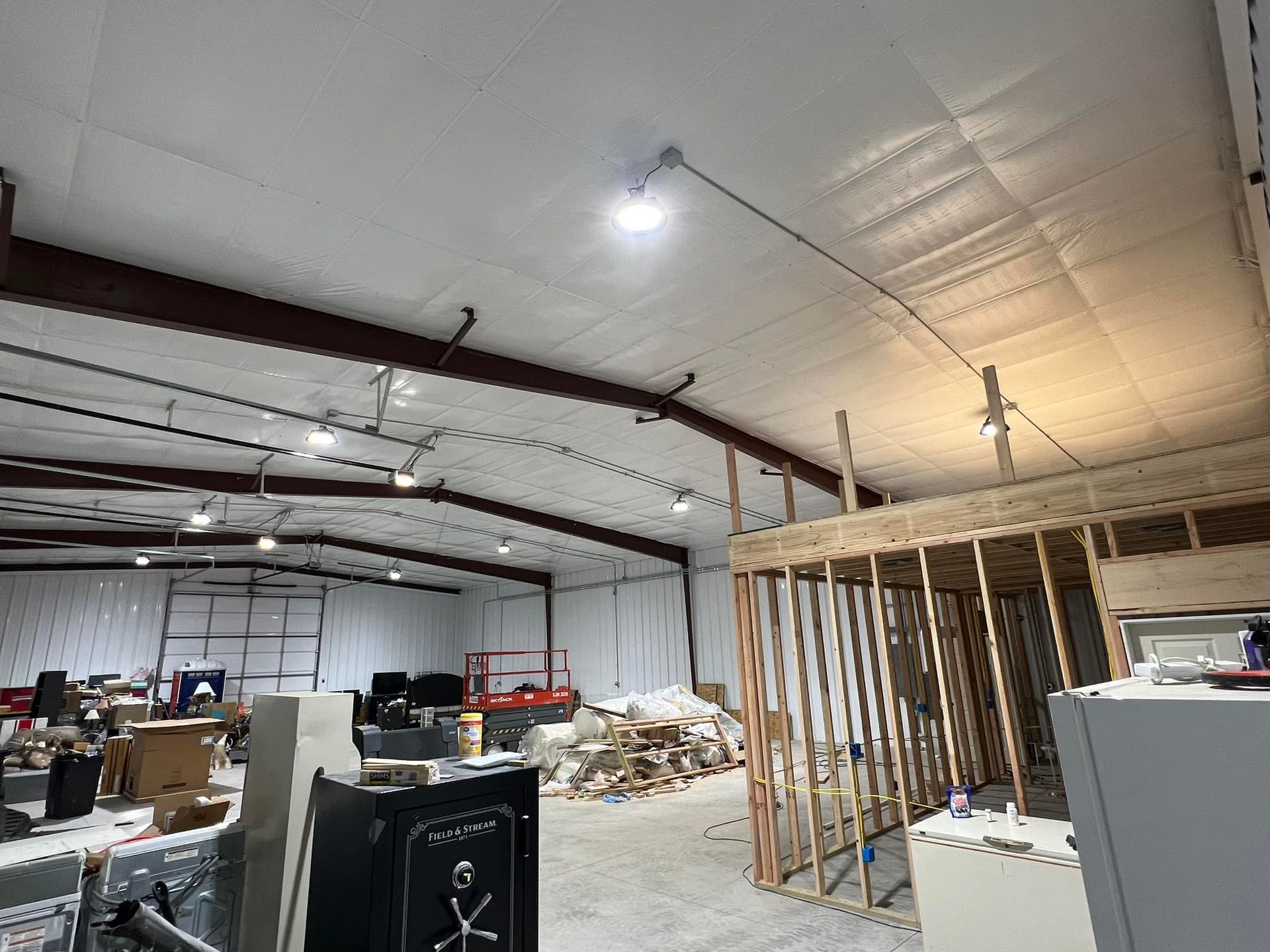 A large warehouse under construction with a lot of boxes on the floor.
