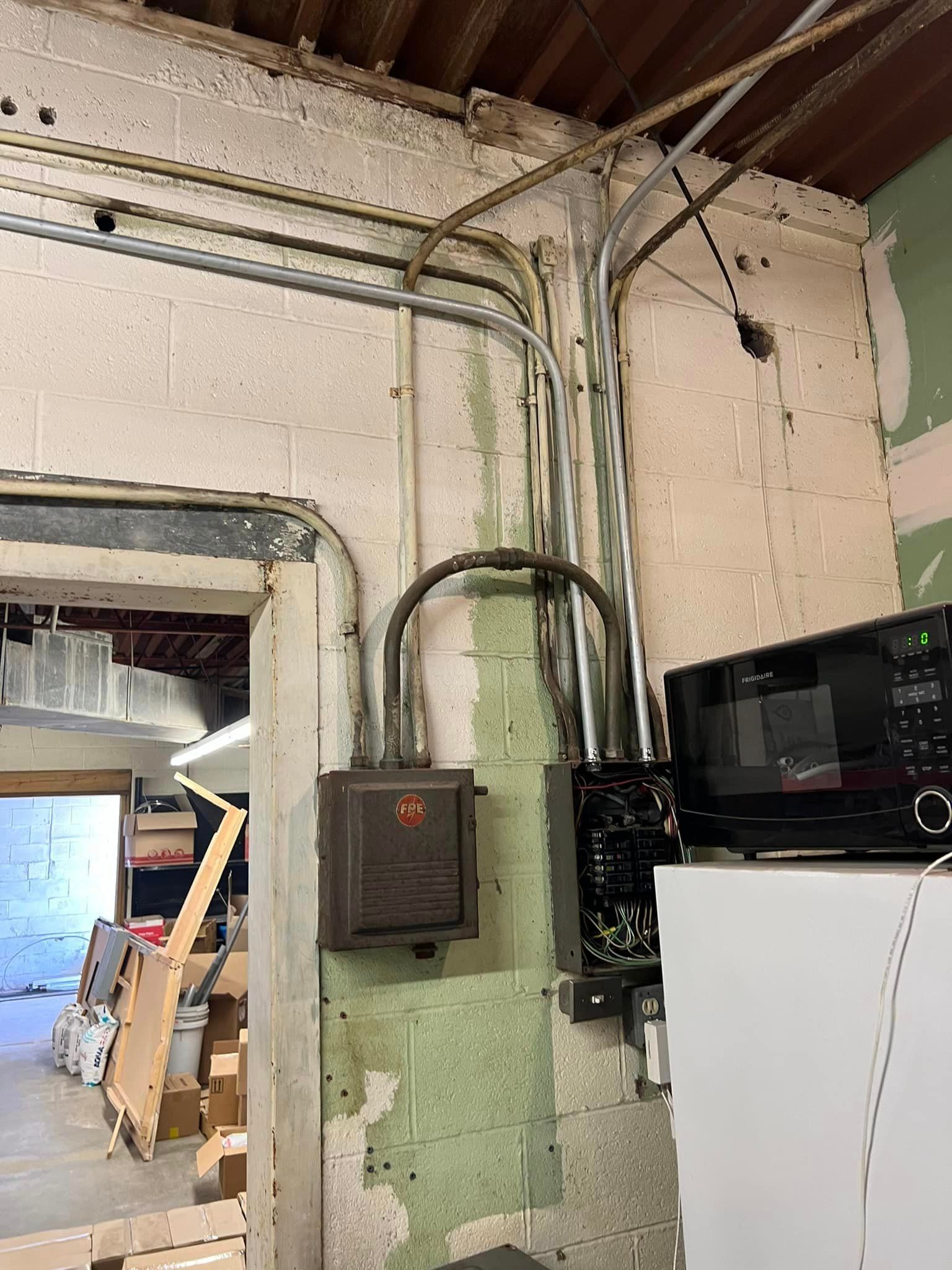 A microwave oven is sitting on top of a white refrigerator in a room.