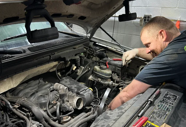 Mechanic working on car engine in a garage; uses tools. | Your Buddy Steve's Garage
