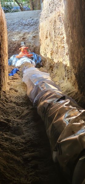 A pipe is being installed in a hole in the ground.
