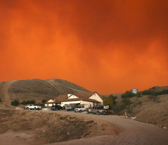 A house on a hill with a red sky in the background