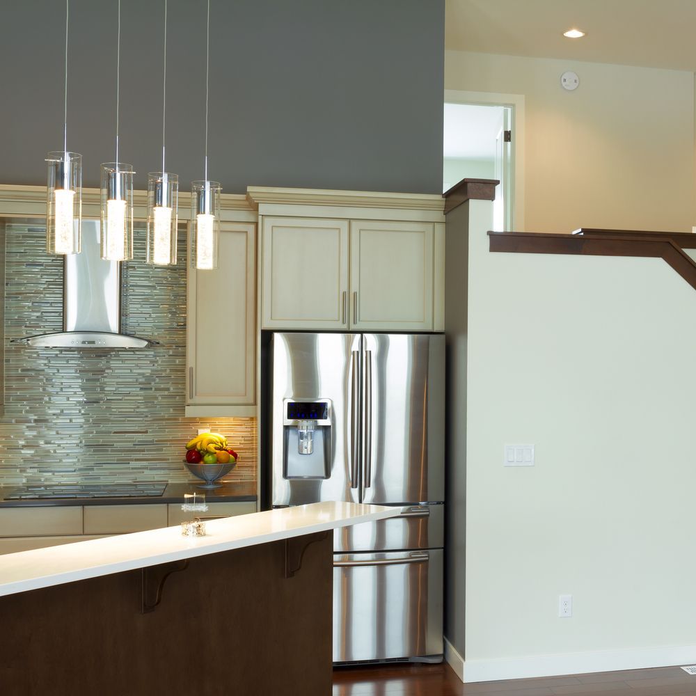 A Kitchen With A Stainless Steel Refrigerator And A Staircase — McGrath Builders & Associates In Corowa, NSW