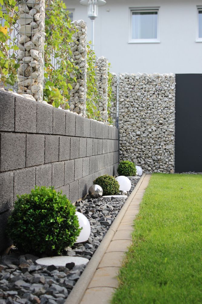 A Stone Wall Surrounds A Lush Green Lawn — McGrath Builders & Associates In Wodonga, VIC