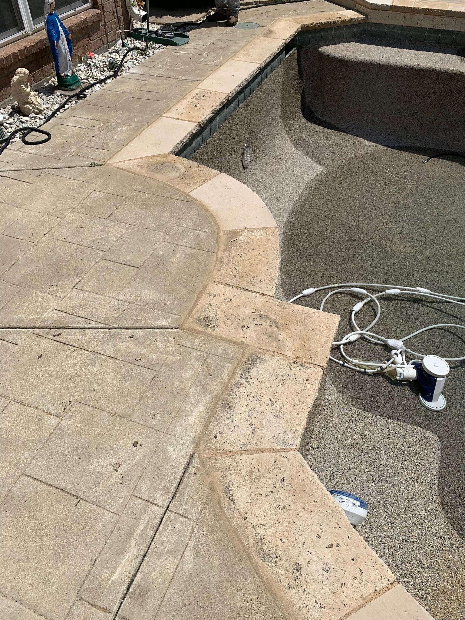 Pool coping with stone border, gray concrete deck, and pool interior.