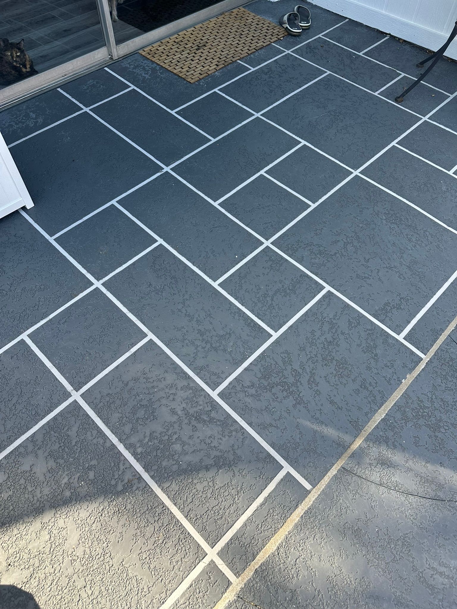 Gray tiled patio with white grout lines.