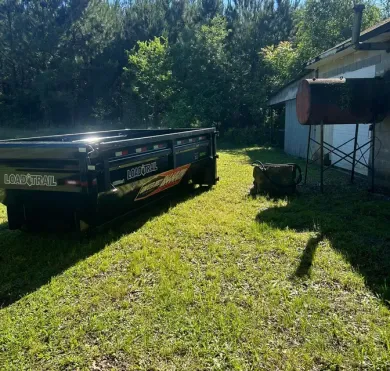 A tow truck is parked in the grass in front of a house.