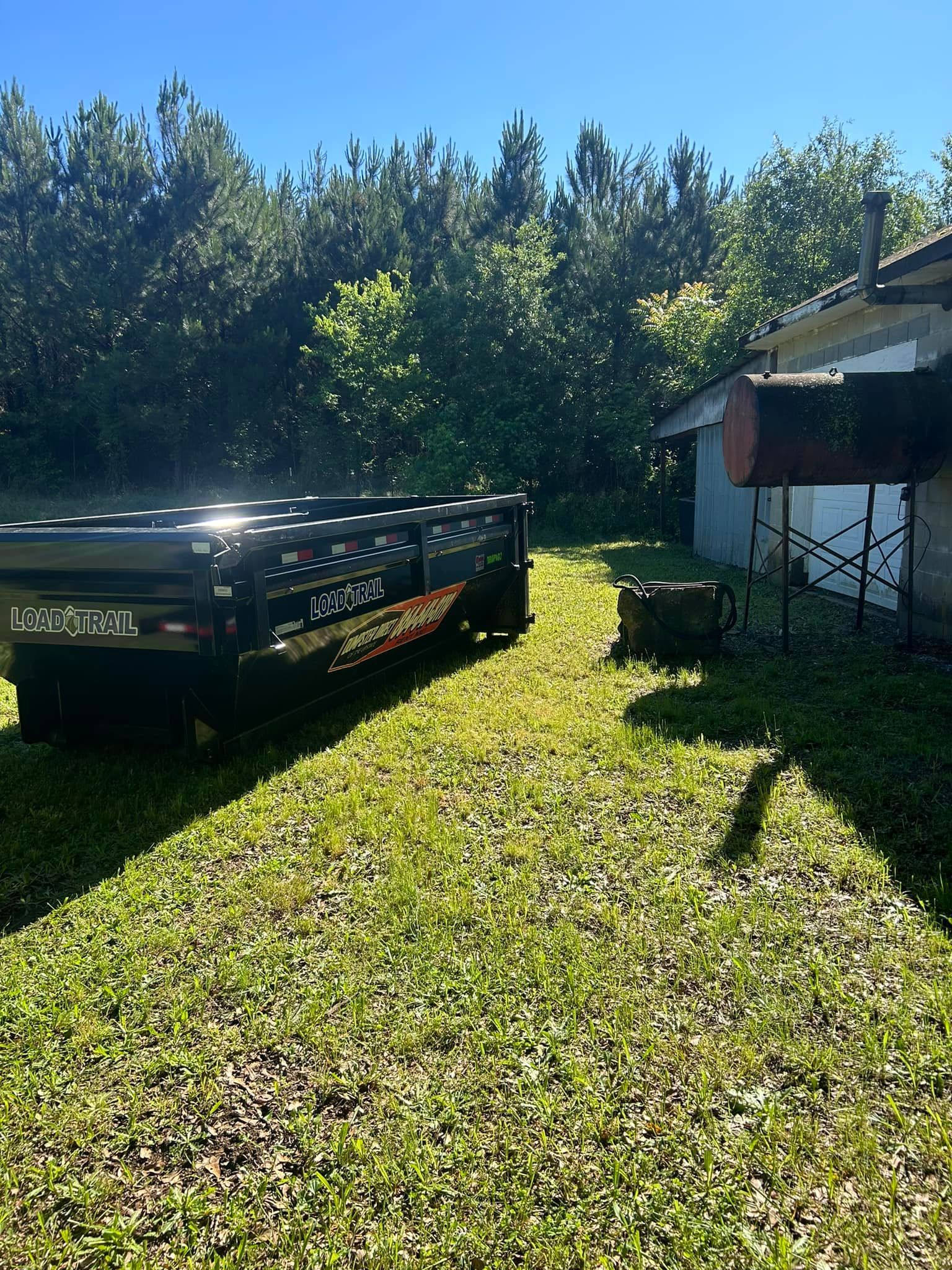 A tow truck is parked in the grass in front of a house.