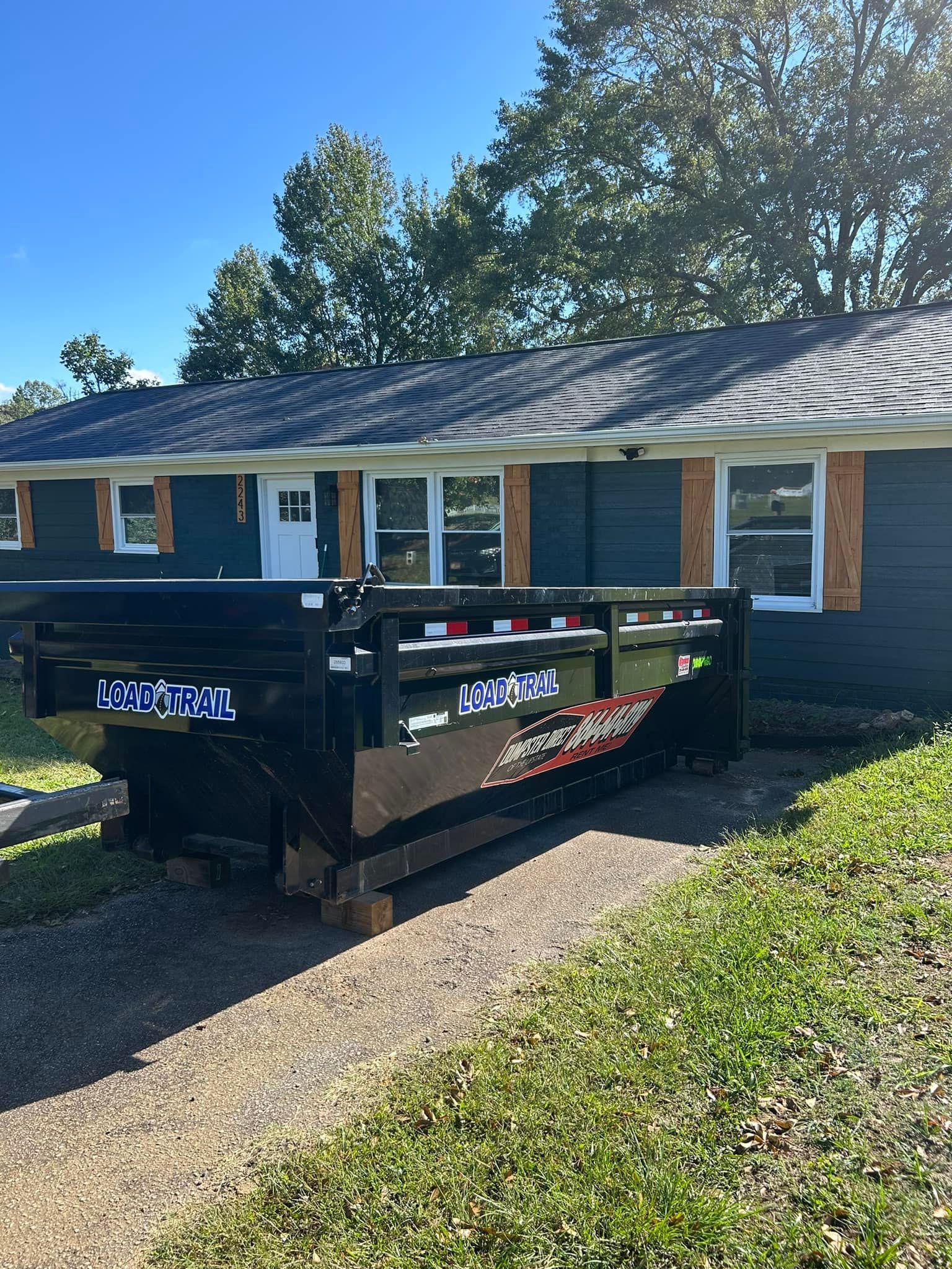 A dumpster is parked in front of a house.