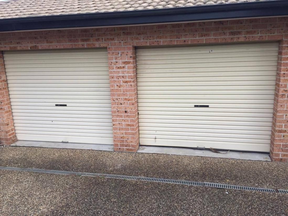 Two White Garage Doors Are Sitting Next to Each Other — P & D Garage Doors in Taree, NSW
