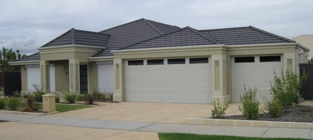 A House With a Gray Roof and White Garage Doors — P & D Garage Doors in Taree, NSW