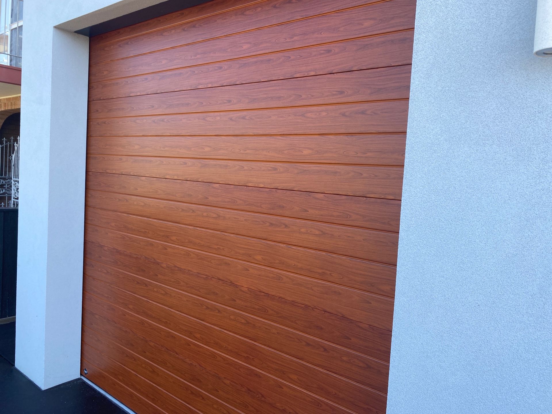 A wooden garage door is on the side of a building — P & D Garage Doors in Taree, NSW