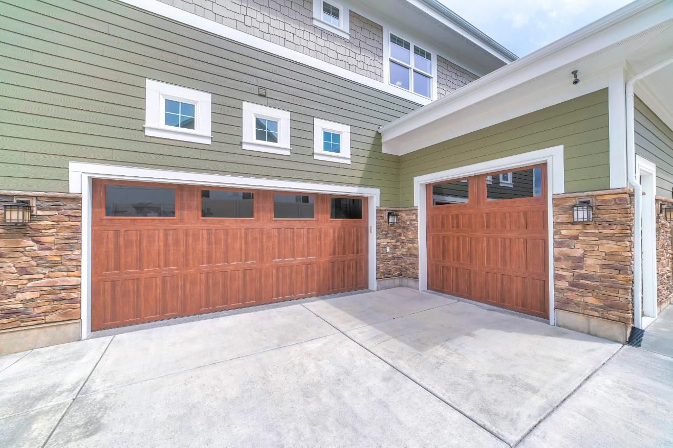 There Are Two Garage Doors in Front of a House — P & D Garage Doors in Laurieton, NSW