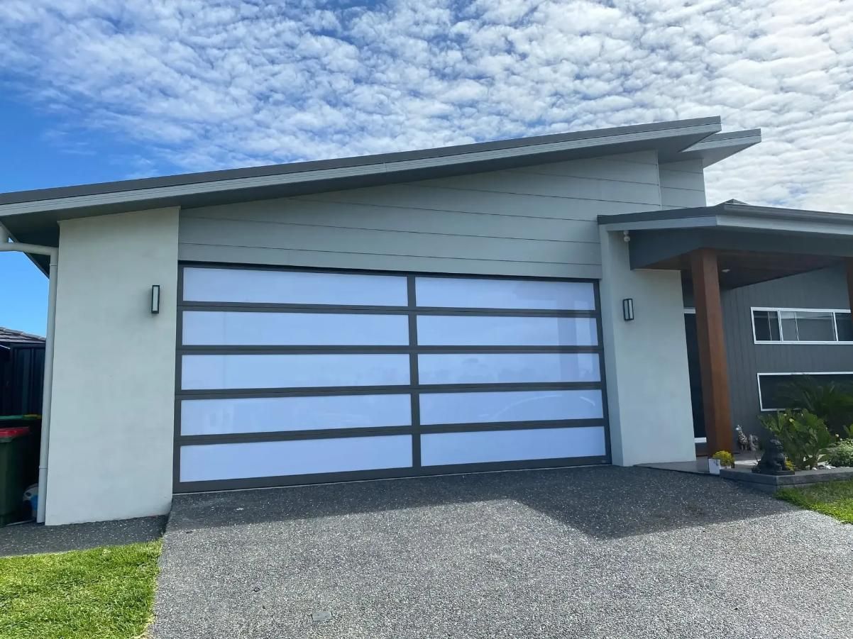 A White House With a Large White Garage Door — P & D Garage Doors in Taree, NSW
