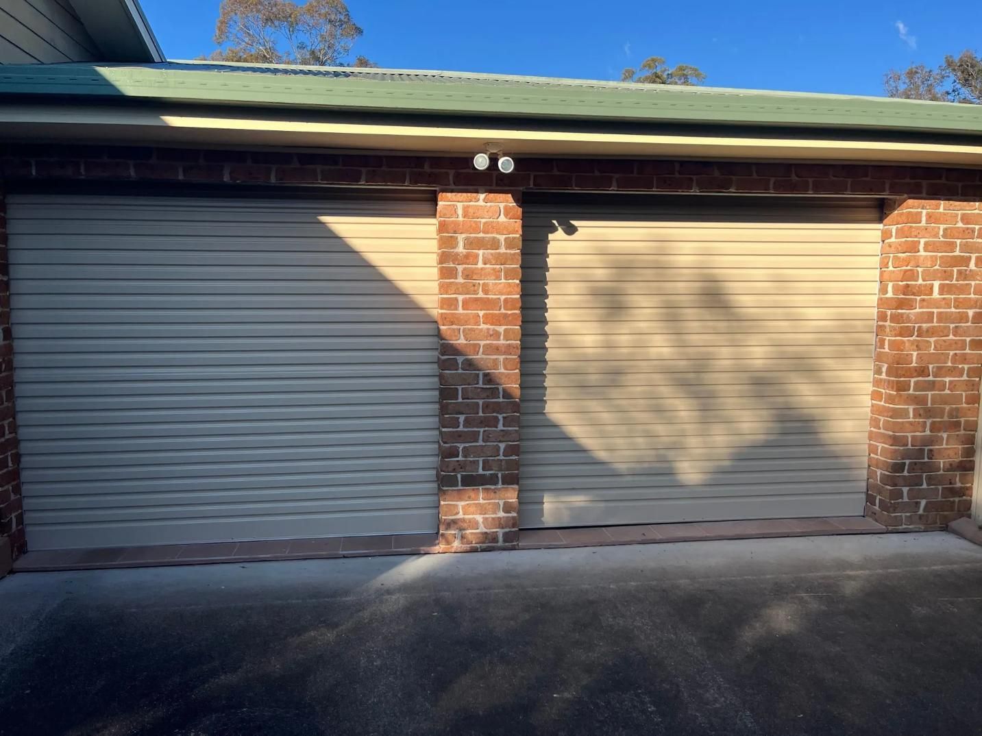 A Garage With Two White Garage Doors — P & D Garage Doors in Taree, NSW