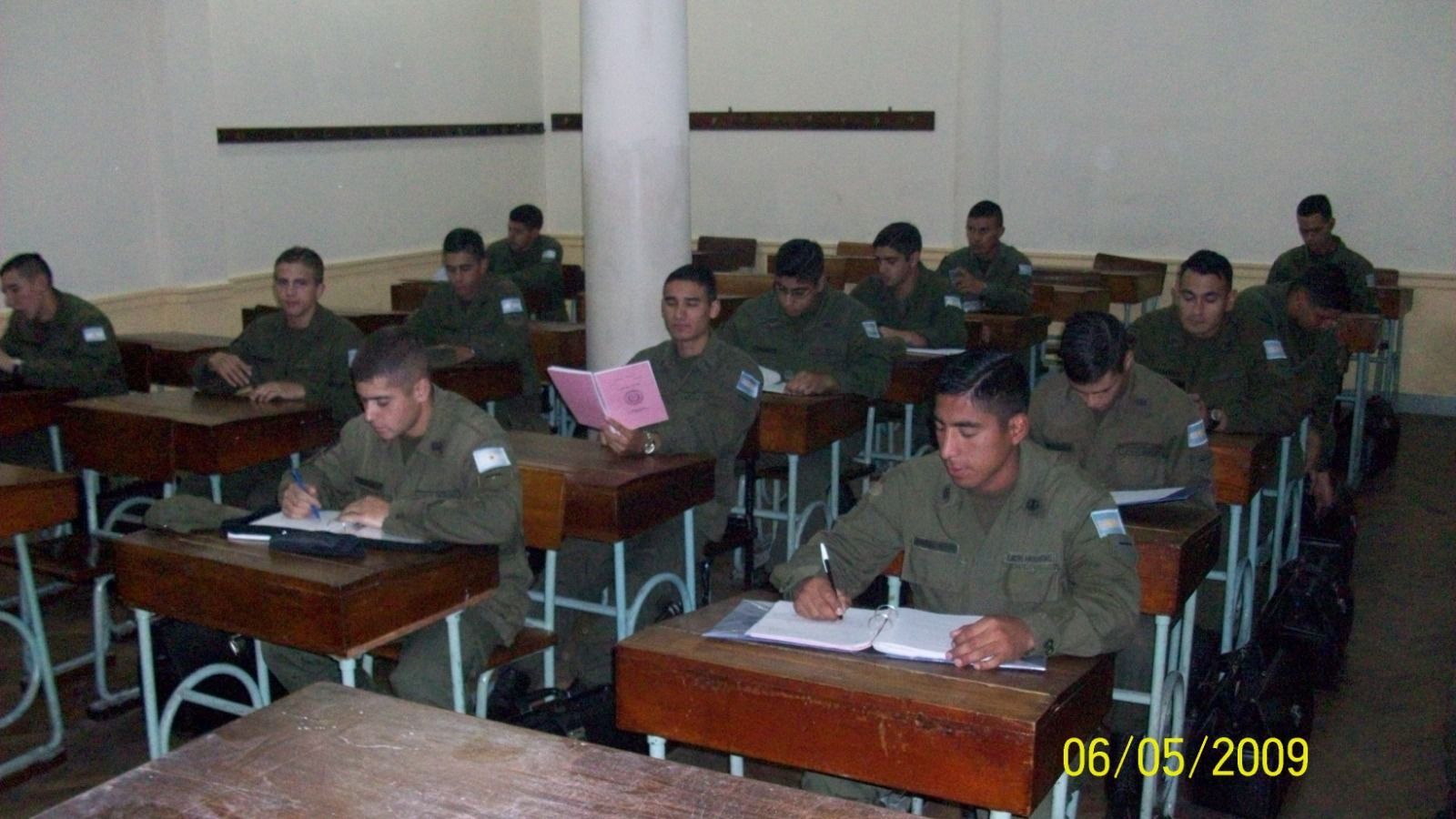 Aula con estudiantes vestidos con uniformes militares; sentados, tomando apuntes. Fecha: 06/05/2009.